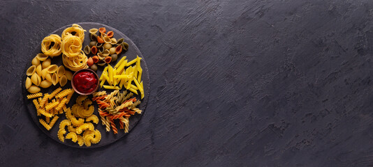 Pasta collection food on table background. Raw pasta assortment at slate stone