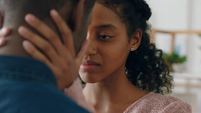 sad young woman touching boyfriends face mixed race couple having relationship trouble emotional issues sharing bad news
