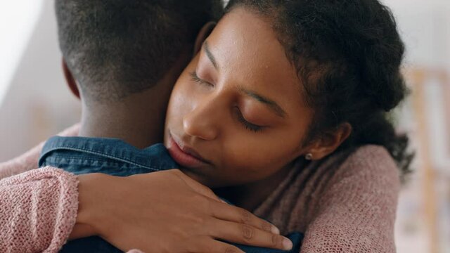 sad young woman hugging boyfriend mixed race couple having relationship trouble embracing emotional issues sharing bad news