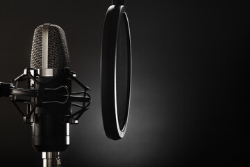 Professional studio microphone on a dark gray background. Minimalism. There are no people in the...