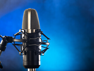 Professional studio microphone on a blue background. There are no people in the photo. Minimalism. Professional recording studio, vocals, conversational genre, debates, interviews, radio. TV.