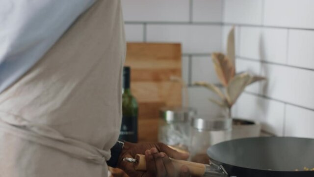 young man chef cooking in kitchen preparing dinner frying vegetables in pan sizzling making delicious homemade meal enjoying healthy lifestyle food at home 4k