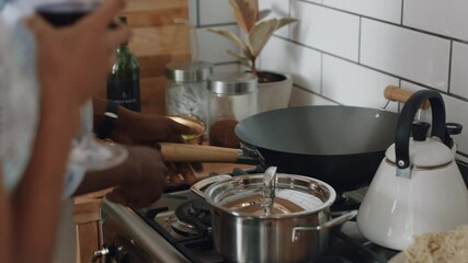 happy young mixed race couple cooking together in kitchen preparing dinner drinking wine enjoying healthy lifestyle making toast celebrating relationship at home 4k