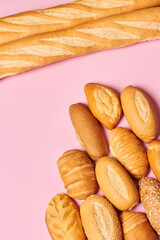 Variety of breads isolated on pink background. Vertical photo.