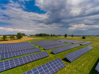 Photovoltaic farm - renewable energy from sunlight - photovoltaic panels set on a green field. Renewable energy supplying medium-sized enterprises