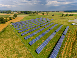 Photovoltaic farm - renewable energy from sunlight - photovoltaic panels set on a green field. Renewable energy supplying medium-sized enterprises