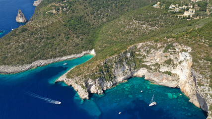 Fototapeta premium Aerial drone photo of tropical exotic paradise bay with deep turquoise sea and caves forming a blue lagoon visited by luxury yachts and sail boats