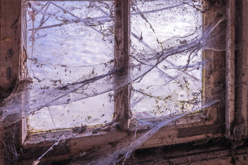 altes Holzfenster mit dicken Spinnweben