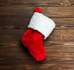 Obraz na płótnie Canvas Christmas sock red on a brown wooden background.