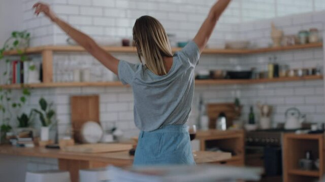 beautiful young woman dancing in kitchen feeling happy enjoying funny dance having fun positive lifestyle at home 4k footage
