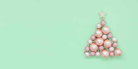 Light green christmas background with christmas tree made of pink christmas balls