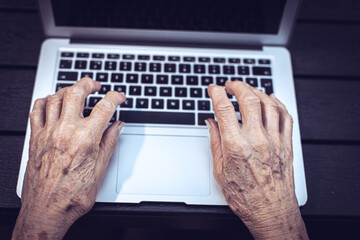 old persons hands on computer keyboard