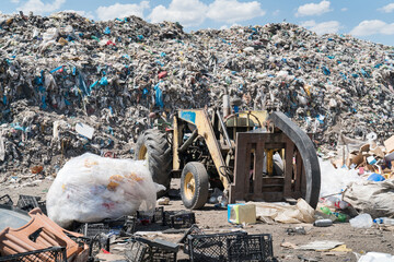 A big pile of garbage smell and toxic residue in the foreground, blue cloudy sky and mountains in...