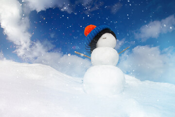 Christmas background, a snowman in a hat stands on a snowdrift