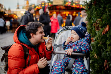 Father and son eating waffle at Christmas market