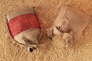 Two mini different wheat jute sacks on wheat grains,top view