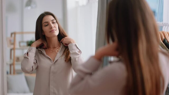 beautiful young woman getting dressed looking in mirror fresh start to new day putting on clothes enjoying morning at home positive self image 4k footage