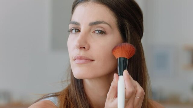 portrait beautiful young woman applying makeup getting ready at home looking in mirror enjoying natural complexion feminine beauty 4k footage