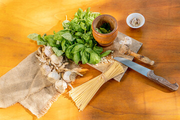 ingredients for a Mediterranean pasta with Genoese pesto sauce on a wooden table seen from above