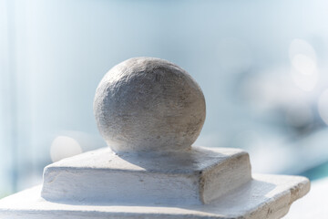 A round concrete ball on the parapet of the fence close-up