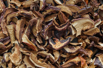 texture background: dried mushrooms Imleria badia (bay bolete) and Boletus edulis (penny bun). Dehydrated mushrooms for cooking top view