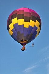 Obraz premium Balloon pilot flying his colorful balloon against the blue skies overhead