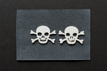 Obraz premium wooden skull and crossbones hand painted in white on textured gray paper