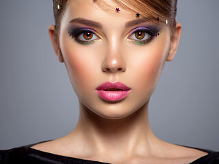 Portrait of a beautiful woman with bright makeup. Closeup model face with multicolored eye make-up....