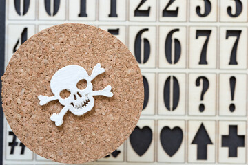 wooden skull and crossbones hand painted in white isolated on cork and number stencil