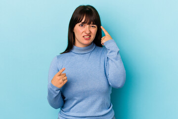 Young curvy caucasian woman isolated on blue background showing a disappointment gesture with...