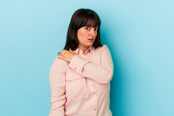 Fototapeta premium Young curvy caucasian woman isolated on blue background having a shoulder pain.