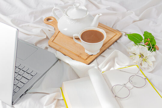 Modern home office desk with laptop, book, tea latte cup on messy bef background. Flat lay, top view. Autumn, fall concept.