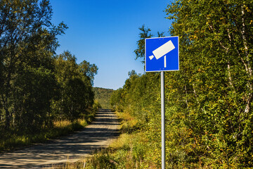 Roadway video surveillance during corona on small mountain forest road between Sweden and Norway - state border closure. Road sign of camera.