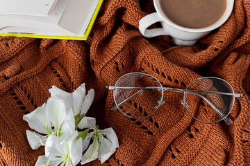Autumn, fall composition. Book, glasses, coffee with milk cup, warm brown pullover. Flat lay, top view.
