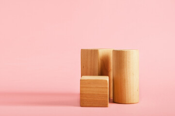 Wooden blocks podiums for goods on pink background. Geometric shapes for presentation of products, cosmetics...