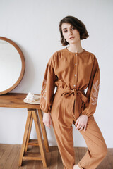 Intriguing woman possing for a photo in a brown jumpsuit