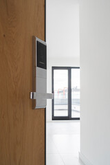 Entrance apartment door designed with wooden pattern and equipped with high tech lock system.