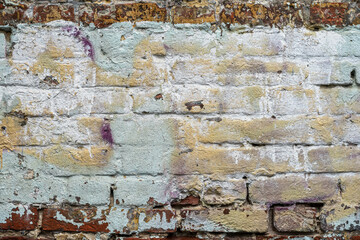 Old brick wall with peeling paint. Close-up texture. Natural vintage background
