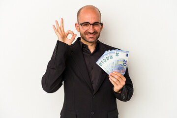 Young business bald man holding bills isolated on white background  cheerful and confident showing...