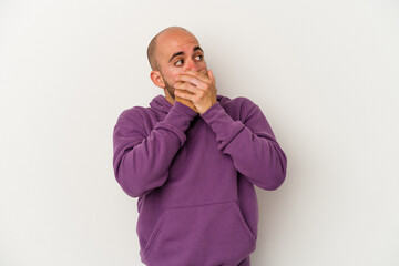 Young bald man isolated on white background thoughtful looking to a copy space covering mouth with hand.