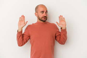 Young bald man isolated on white background being shocked due to an imminent danger