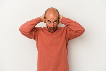 Young bald man isolated on white background screaming, very excited, passionate, satisfied with...