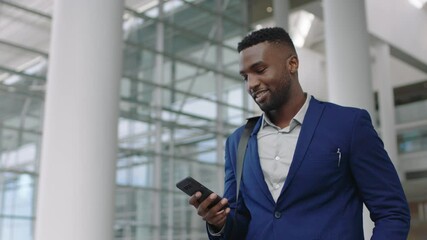 young african american businessman using smartphone texting walking in corporate office building checking email messages online successful male executive arriving at work 4k - Powered by Adobe