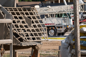 Cement mixer at a construction site with crane in the background