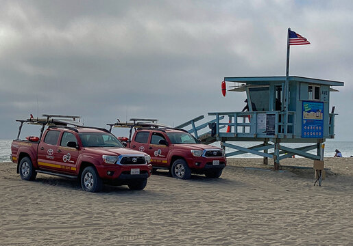 Redondo Beach, California - June 27, 2021: Los Angeles County lifeguard trucks and guard tower on the beach of the Pacific Ocean