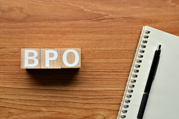 On a wood board, wooden word cubes are arranged in the letters BPO. It is an abbreviation for...
