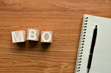 On a wood board, wooden word cubes are arranged in the letters MBO. It is an abbreviation for...