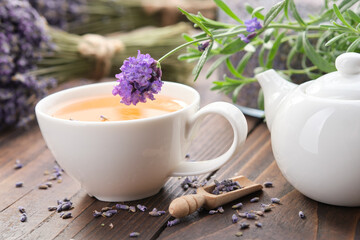 Obraz na płótnie Canvas Healthy lavender herbal tea cup, tea kettle, fresh and dry lavender flowers on wooden table.