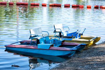 Fototapeta na wymiar Catamarans on the bank of the river on summer bright day under blue sky.