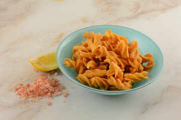 Lemon Himalayan pink salt pea snack in blue snack bowl with lemon slice and pile of Himalayan salt